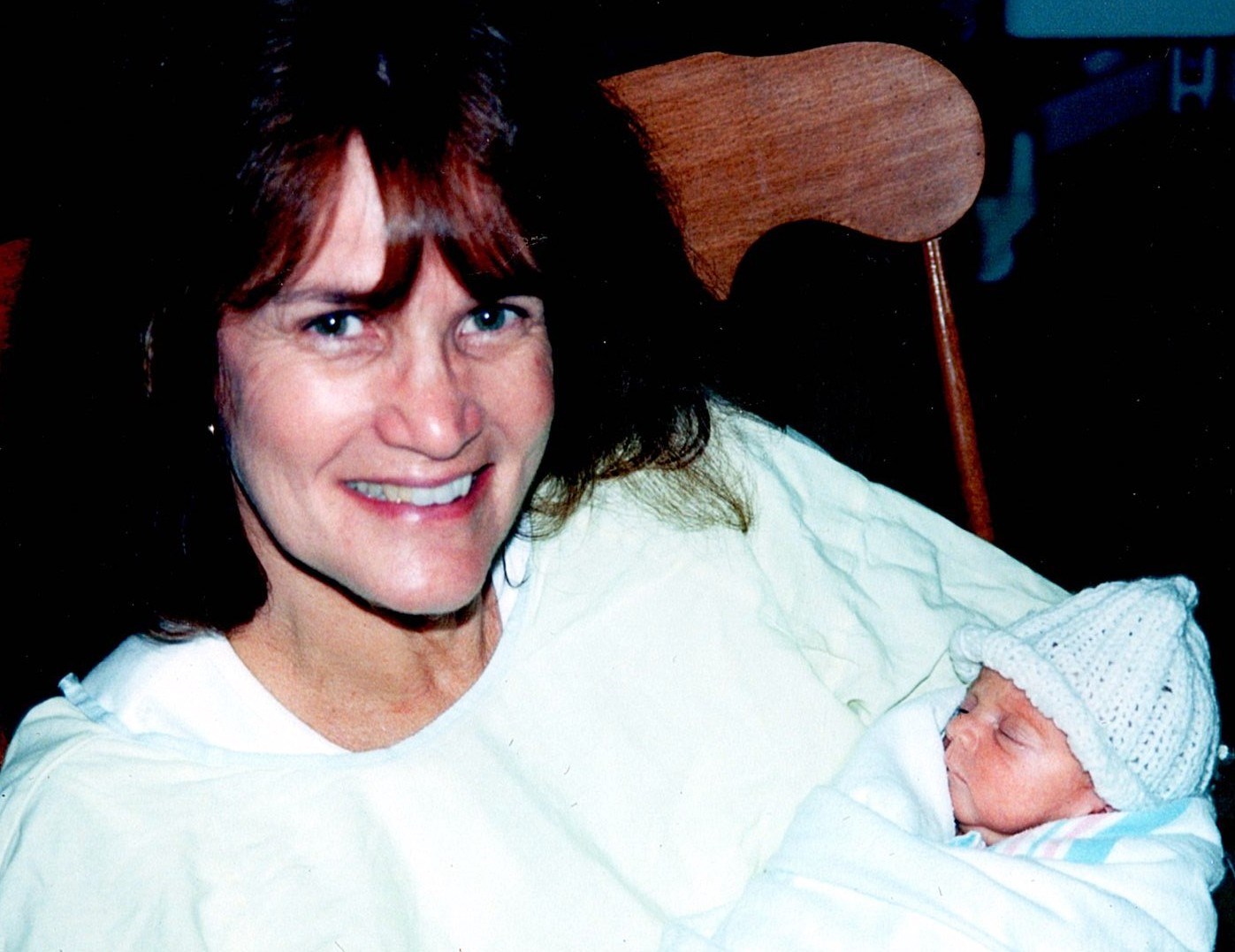 Ann Filipone smiling while holding a sleeping newborn