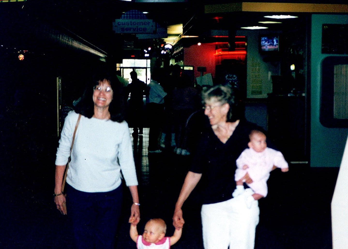 Ann Filipone sitting on the floor beside a child opening gifts
