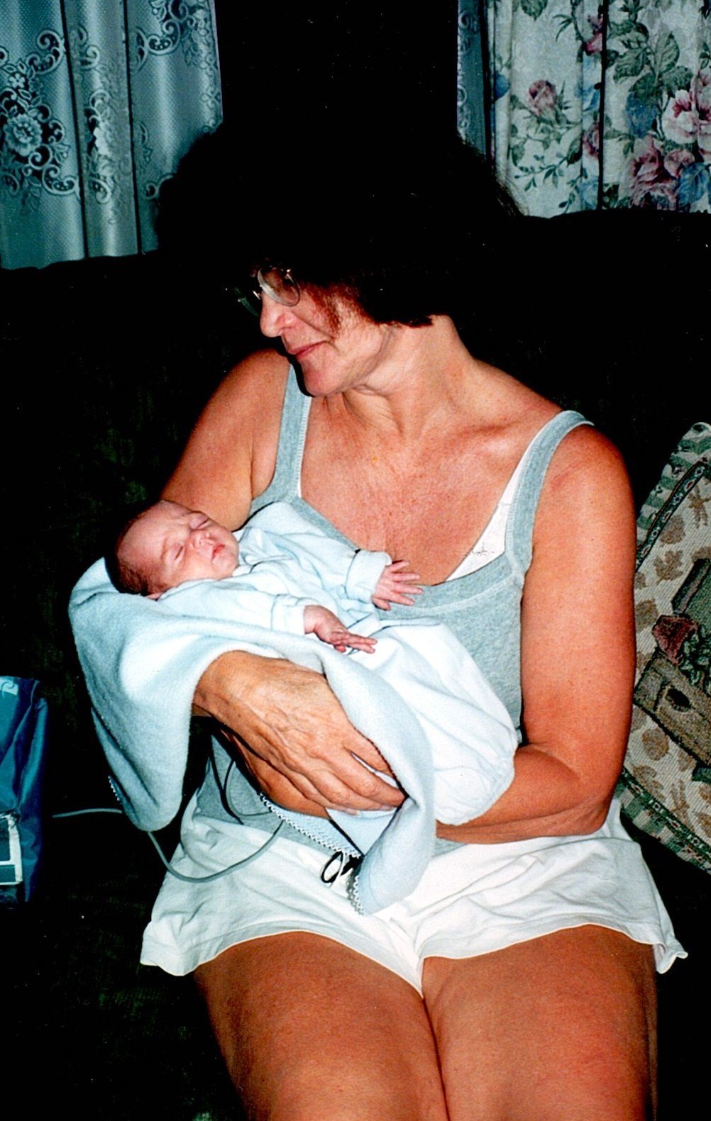 Ann Filipone cradling a newborn on a couch