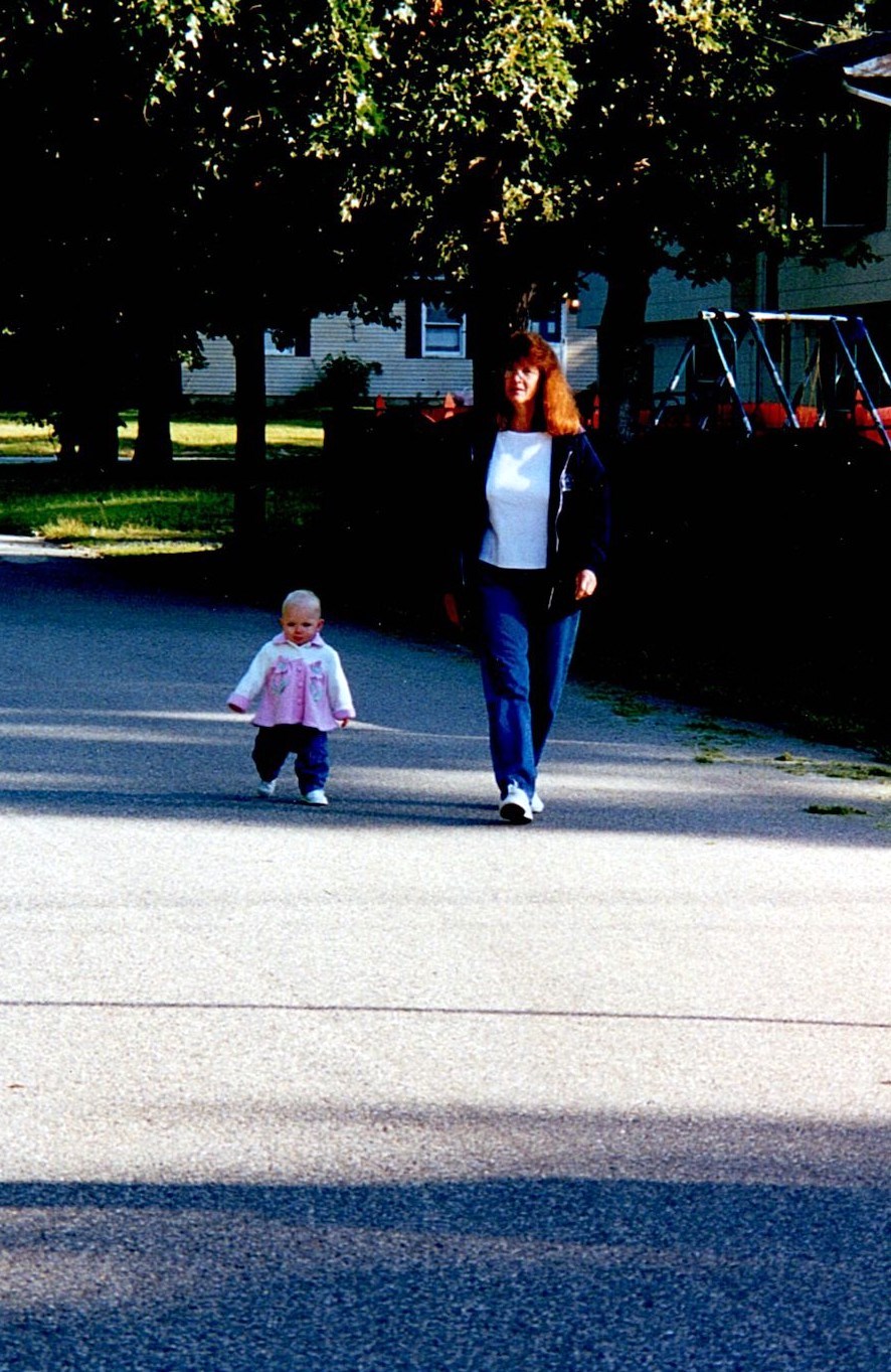 Ann Filipone walking down a neighborhood street with a young child