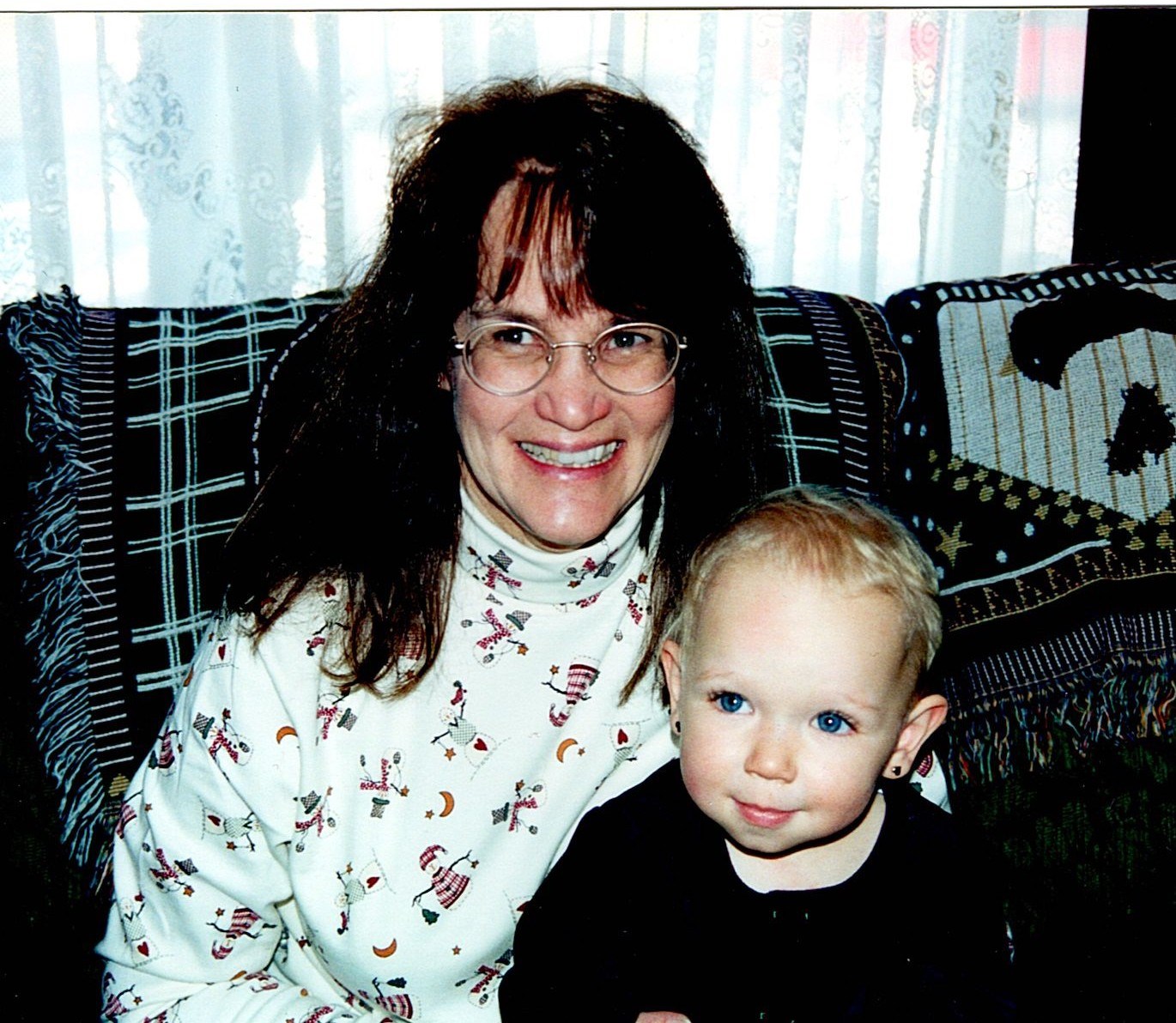 Ann Filipone smiling beside a young child on a couch