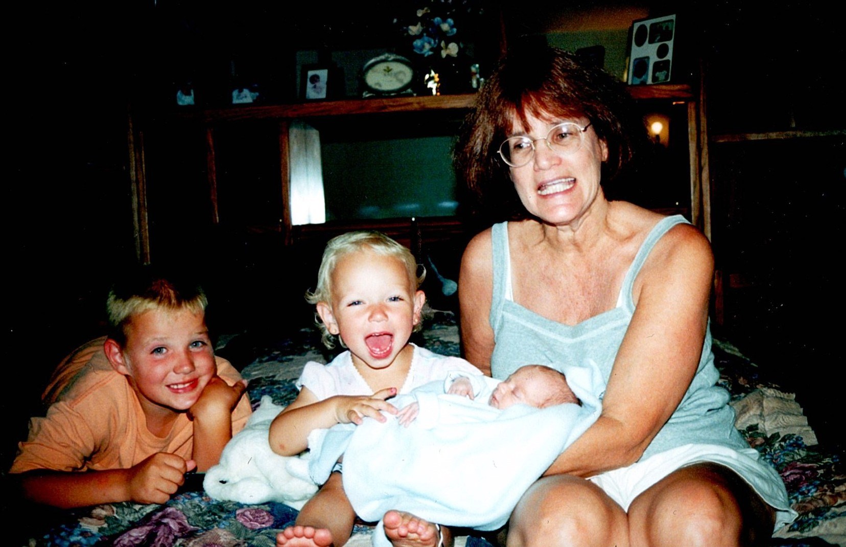 Ann Filipone sitting with children and a newborn on a bed