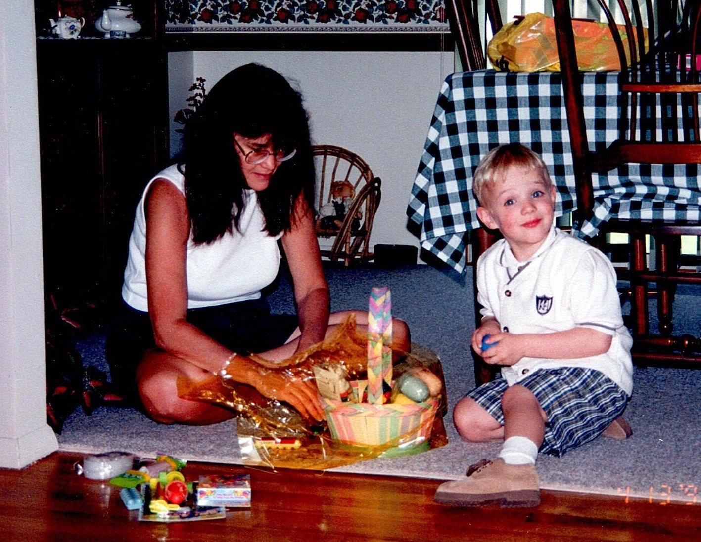 Ann Filipone sitting on the floor beside a child during an Easter activity